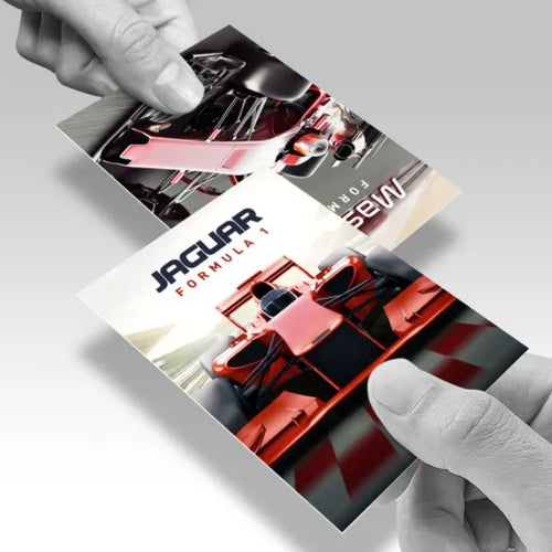 PERSON HOLDING A CUSTOM PRINTED JAGUAR FORMULA 1 CARD FEATURING A RACE CAR DESIGN ON THE COVER.
