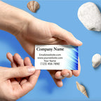 CUSTOM PRINTED BUSINESS CARD WITH BLUE GRAPHICS AND CONTACT INFORMATION BEING HANDED FROM ONE PERSON TO ANOTHER AGAINST A BLUE BACKGROUND.