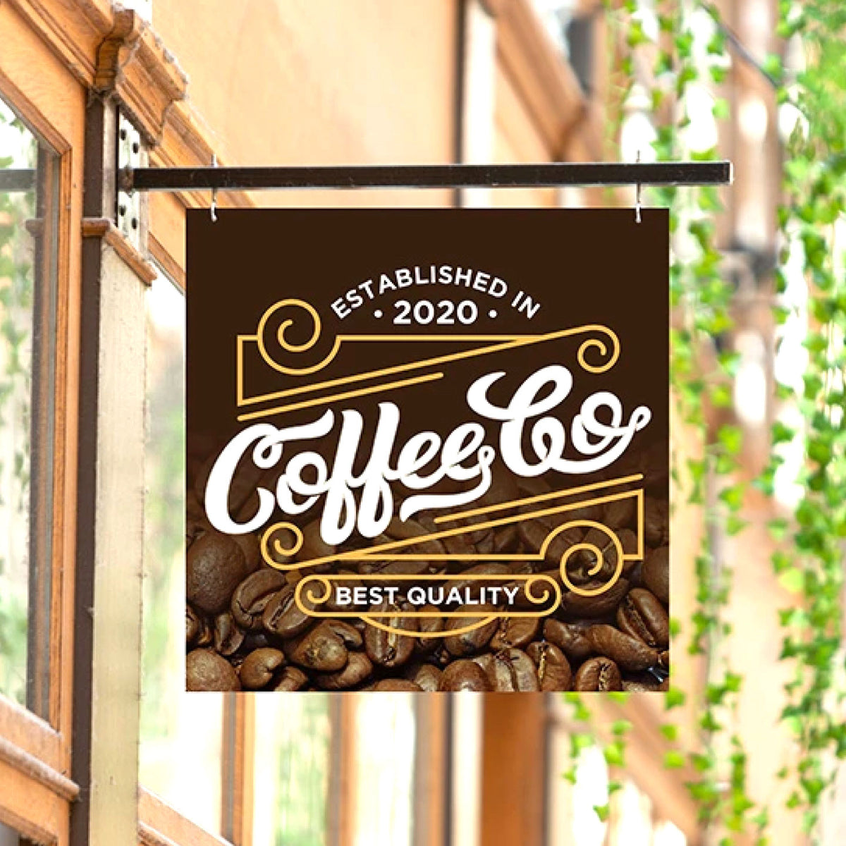CUSTOM PRINTED ALUMINUM COFFEE SHOP SIGN FEATURING COFFEE & CO BRANDING WITH WHITE AND GOLD GRAPHICS AND COFFEE BEANS, HANGING FROM A BLACK METAL BRACKET OUTSIDE A STOREFRONT.