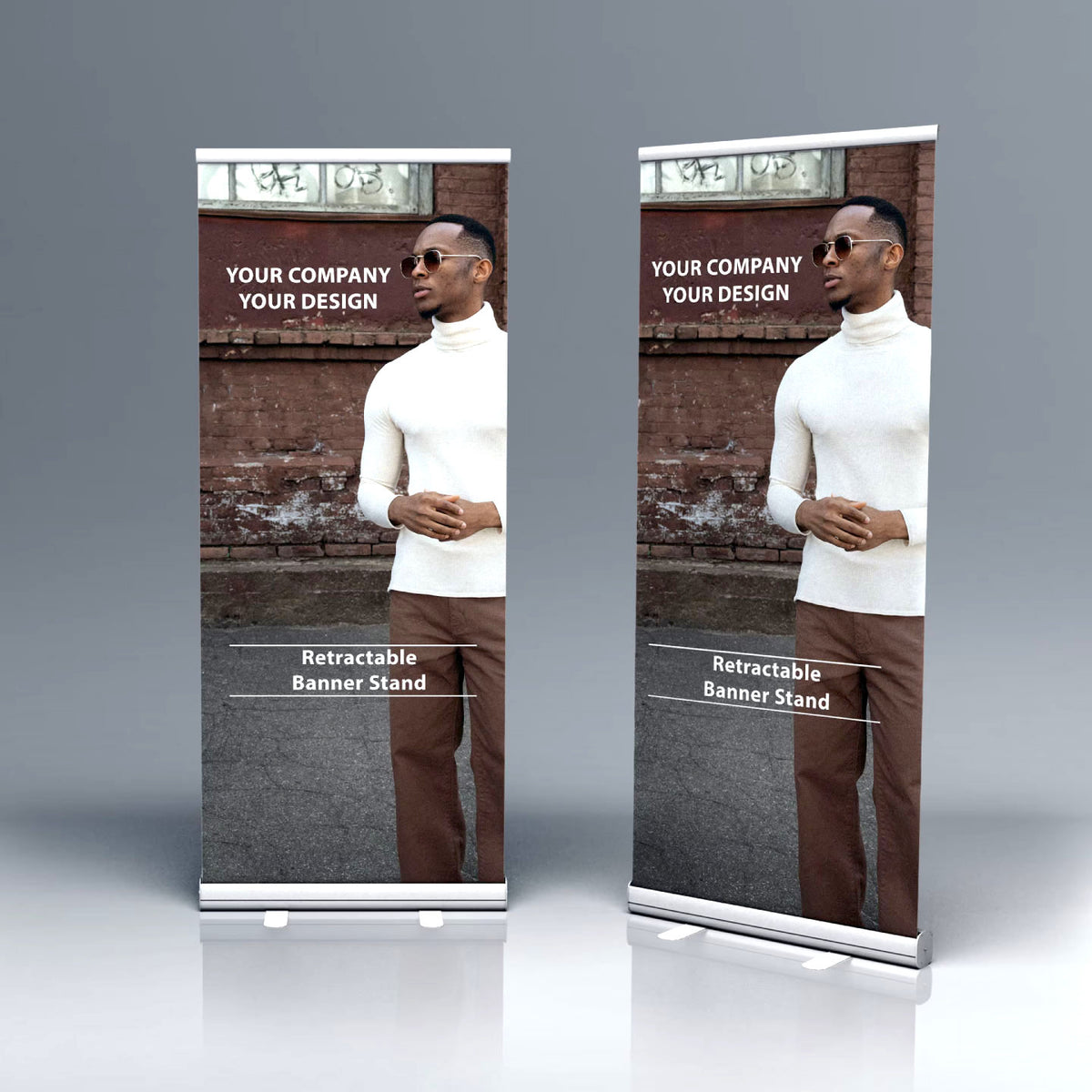 TWO ECONOMY RETRACTABLE BANNER STANDS FEATURING CUSTOM FULL-COLOR PRINTED PROMOTIONAL GRAPHICS OF A MAN POSING AGAINST A BRICK WALL, DISPLAYED ON A GRAY STUDIO BACKGROUND.