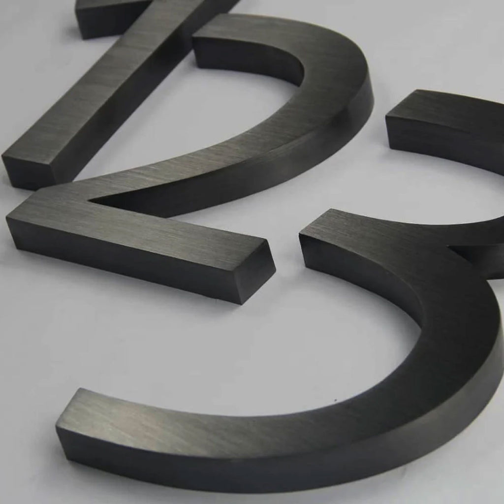 MATTE BLACK 3D METAL NUMBERS FEATURING “2” AND “3” WITH A BRUSHED FINISH, DISPLAYED ON A LIGHT GRAY BACKGROUND.