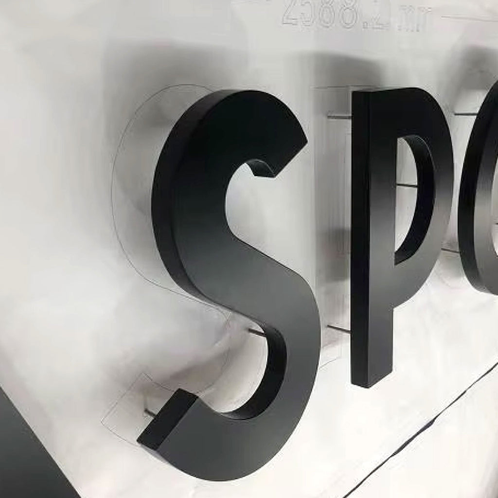 BLACK 3D LETTERS “S” AND “P” MOUNTED ON STUDS WITH A VISIBLE GAP BETWEEN THE LETTERS AND WALL.