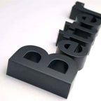 BLACK FABRICATED 3D BLOCK LETTERS SPELLING “BETTER,” ARRANGED DIAGONALLY ON A CLEAN WHITE BACKGROUND.