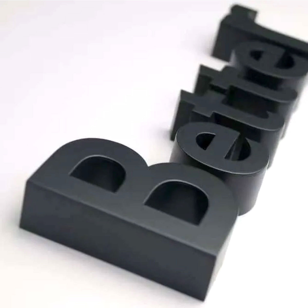 BLACK FABRICATED 3D BLOCK LETTERS SPELLING “BETTER,” ARRANGED DIAGONALLY ON A CLEAN WHITE BACKGROUND.