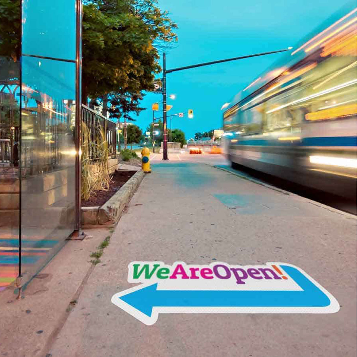 CUSTOM PRINTED ANTI-SLIP OUTDOOR FLOOR GRAPHIC FEATURING A “WE ARE OPEN!” DIRECTIONAL ARROW, APPLIED TO A ROUGH CONCRETE SIDEWALK FOR DURABLE, HIGH-IMPACT WAYFINDING AND PROMOTIONAL SIGNAGE.