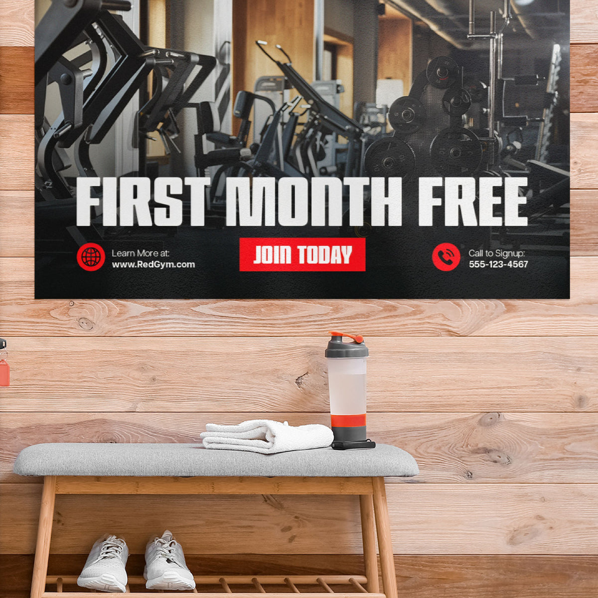 CUSTOM PRINTED NO EDGE CURL BANNER FEATURING A GYM PROMOTION WITH “FIRST MONTH FREE” AND “JOIN TODAY” MESSAGING, DISPLAYED FLAT ON A WOOD-PANELED WALL ABOVE A GYM BENCH.