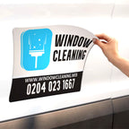 CUSTOM PRINTED VEHICLE MAGNET SIGN FEATURING WINDOW CLEANING BUSINESS BRANDING, LOGO, AND CONTACT INFORMATION, APPLIED TO THE SIDE OF A WHITE CAR FOR REMOVABLE BUSINESS ADVERTISING.